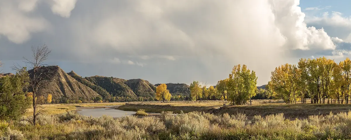 North Dakota: The Little Missouri River and storm clouds just before sunset in the south unit of Theodore Roosevelt National Park, North Dakota, USA